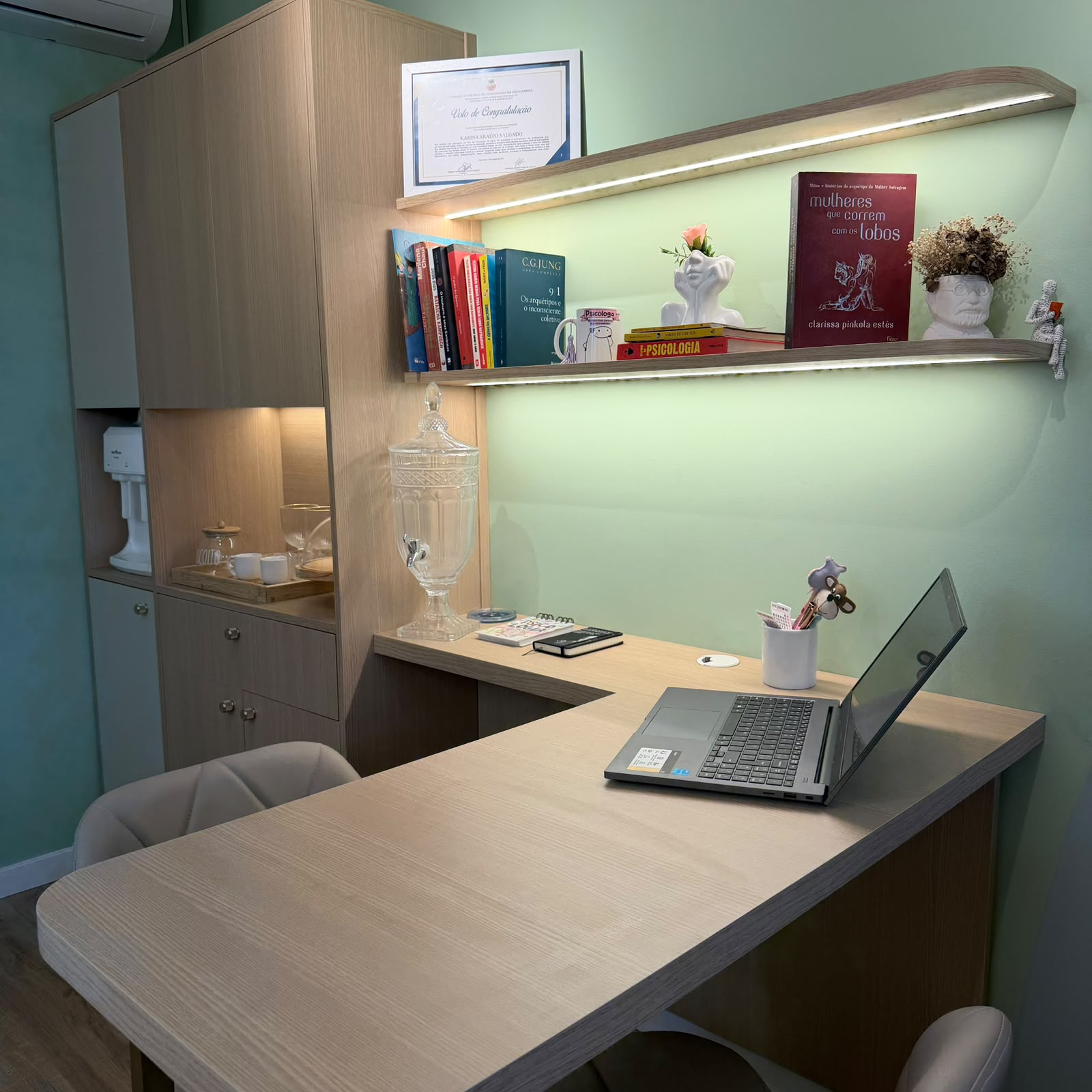 Mesa de trabalho e estante com livros no consultório